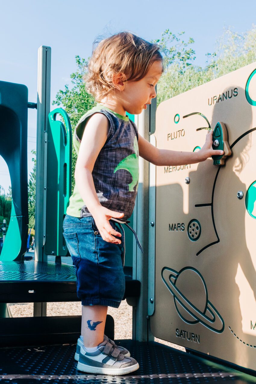 A two year old in a dinosaur tank top