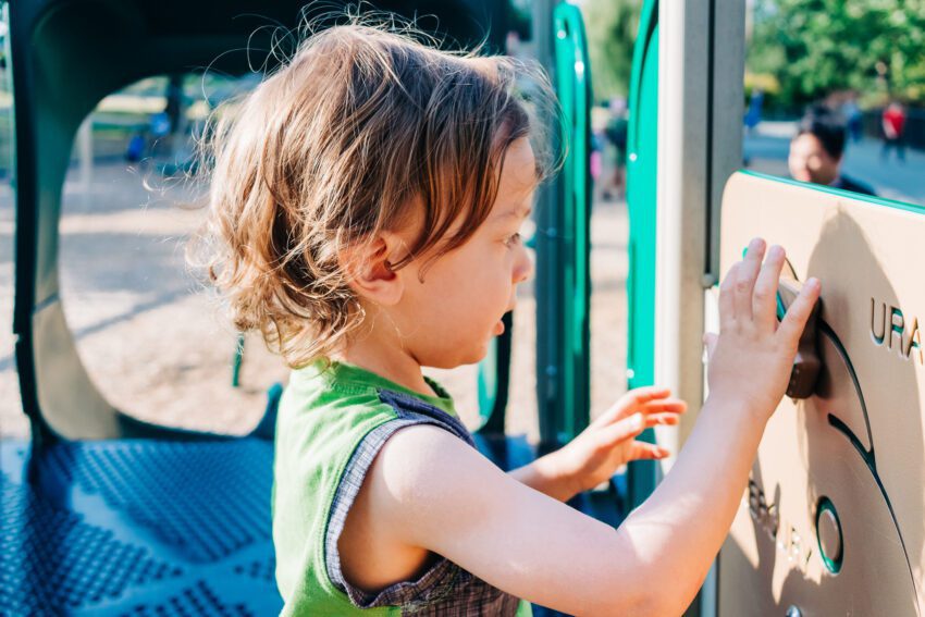 A two year old in a dinosaur tank top