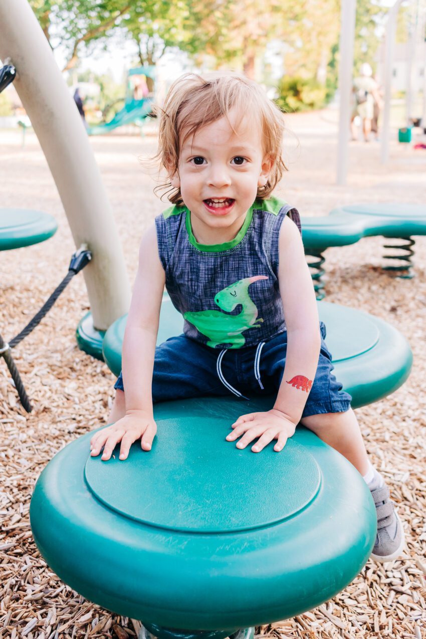 A two year old in a dinosaur tank top