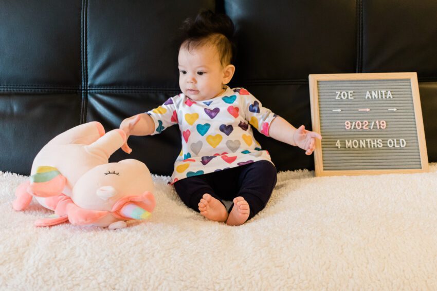 A baby knocking over a stuffed unicorn