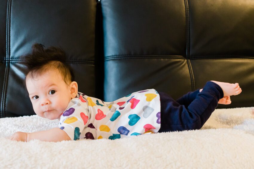 4 month old in colorful heart dress and blue pants